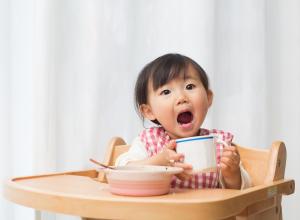 Child eating food and showing teeth