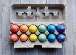 Coloured eggs in an egg carton.