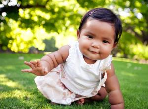 Baby girl crawling on grass