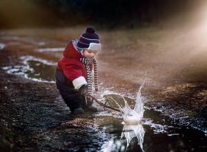 Child playing in puddle.