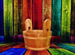 Wooden bucket on colourful panels.
