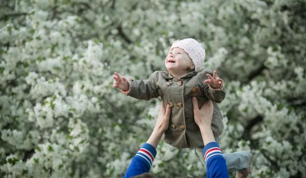 Young boy with Down Syndrome being lifted up