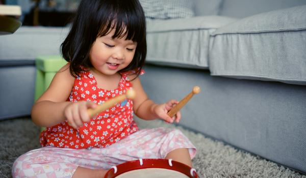 Little girl playing the drum