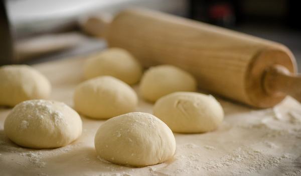 Pizza dough and rolling pin on a table