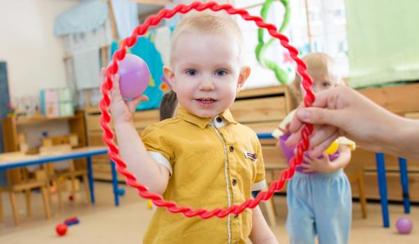 Child looking through hoola hoop that can be used to play Jack and Jill