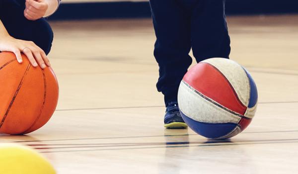 Adult and child playing with basketballs