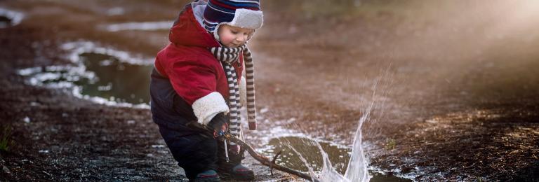 Child playing in puddle.